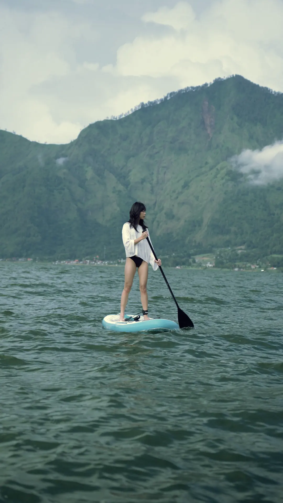 One person stand-up paddleboarding on Lake Batur.