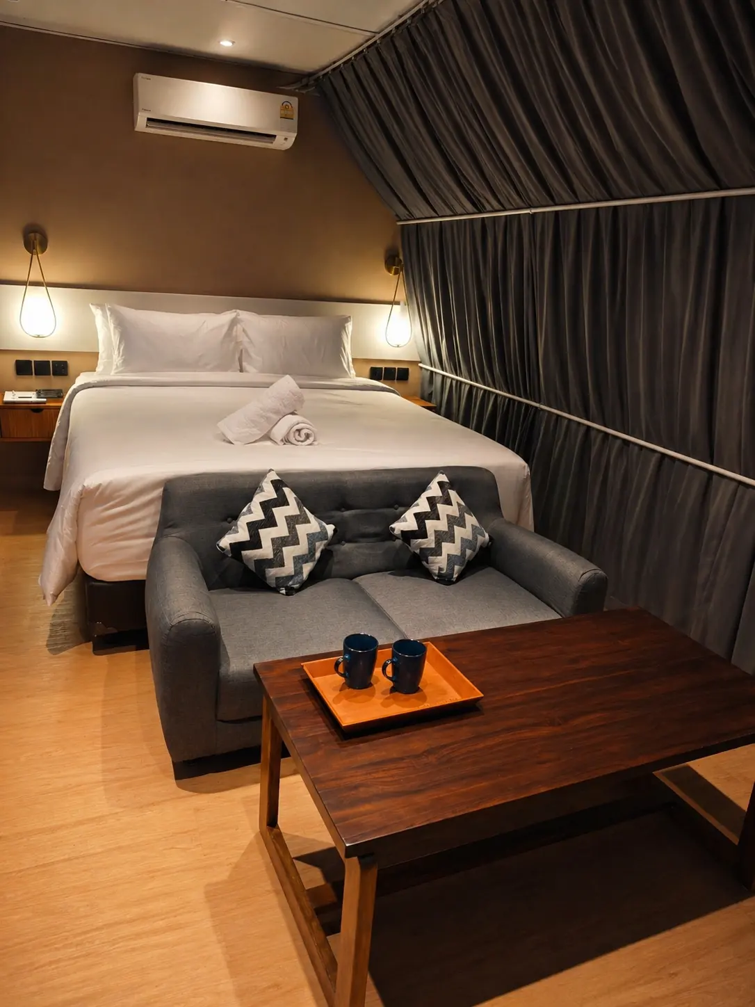 Warm night interior inside Crystal Nest Suites with sofa and bed.